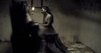 a woman sitting at a piano in a dark room