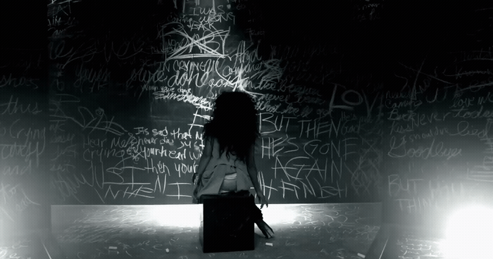 a woman standing in front of a wall covered in graffiti