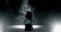 a woman standing in front of a wall covered in graffiti