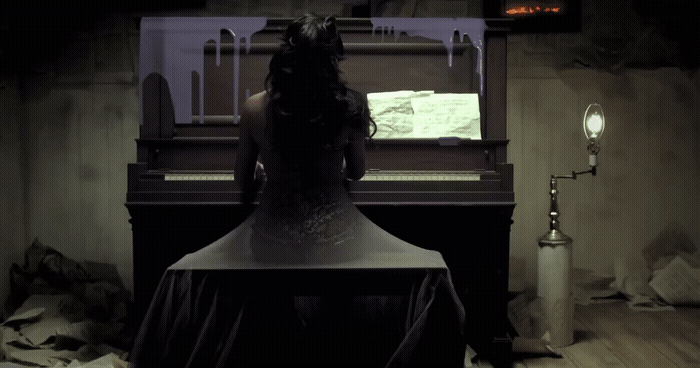 a woman sitting at a piano in a dark room