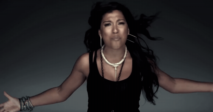 a woman in a black top is holding her arms out