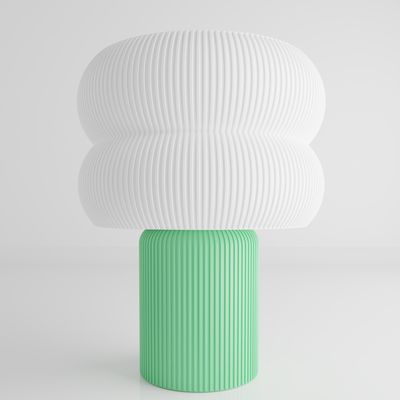 a green and white vase sitting on top of a table