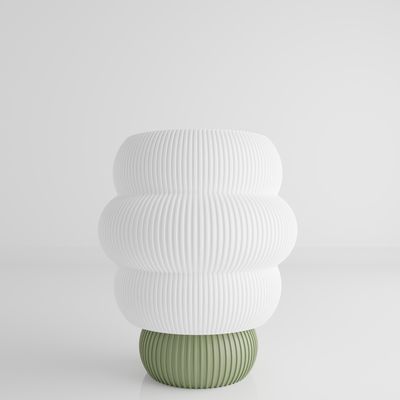 a white and green vase sitting on top of a table