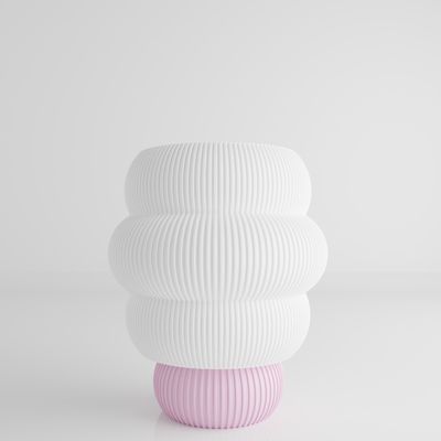 a white and pink vase sitting on top of a table