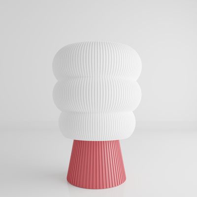 a white and pink vase sitting on top of a table