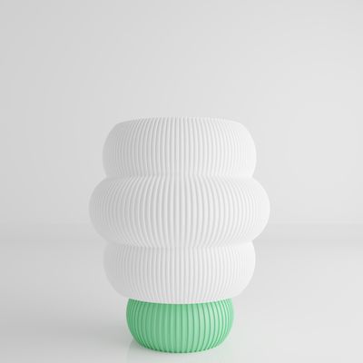 a green and white vase sitting on top of a table