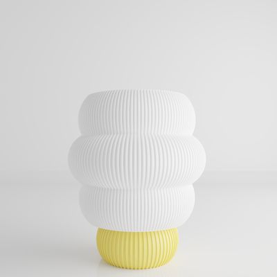 a white and yellow vase sitting on top of a table