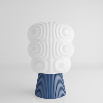 a white and blue vase sitting on top of a table