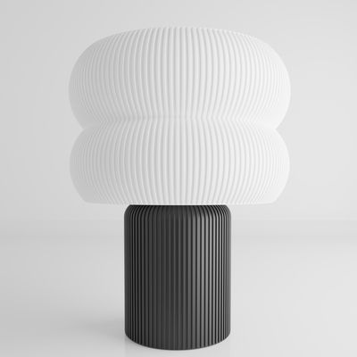 a black and white lamp with a white shade on top of it