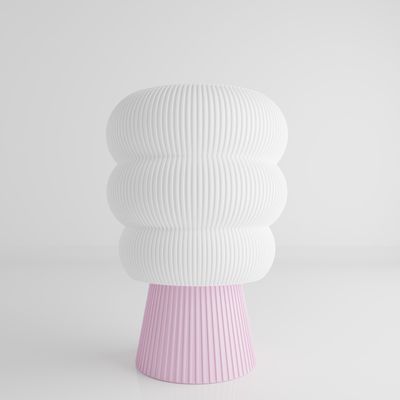 a white and pink vase sitting on top of a table