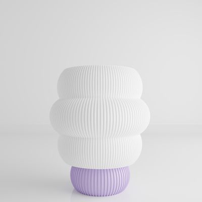 a white and purple vase sitting on top of a table