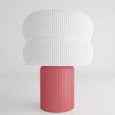 a pink and white vase sitting on top of a white table