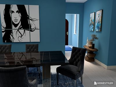 a dining room with blue walls and a painting on the wall