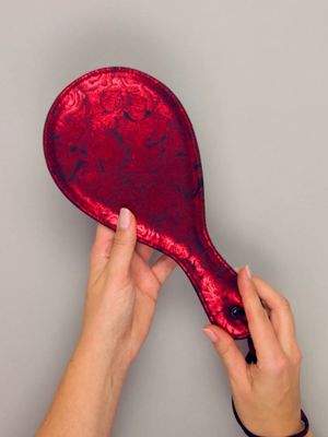 a person holding a red paddle over a gray background
