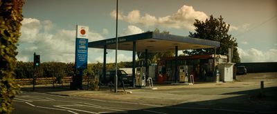 a gas station with a gas pump on the side of the road