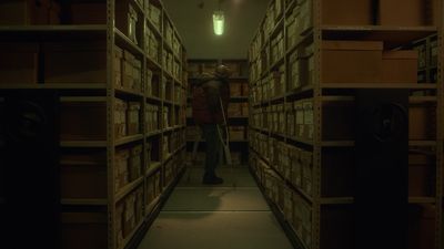 a man standing in a dark room with stacks of boxes