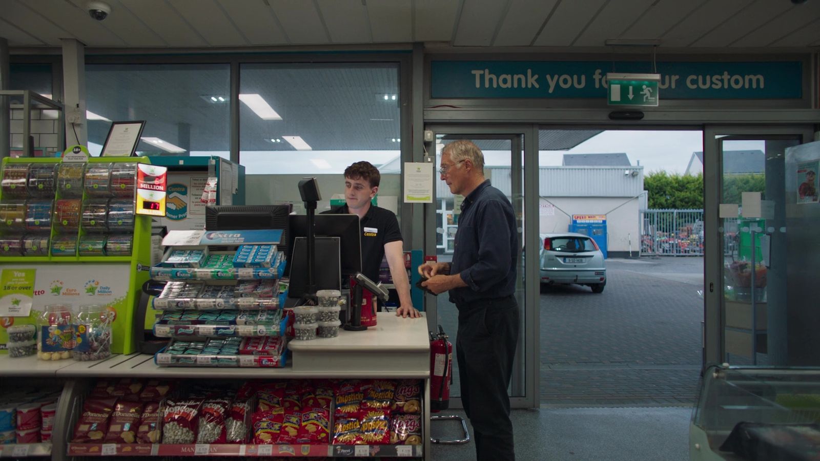 a man and a woman standing at a cash register