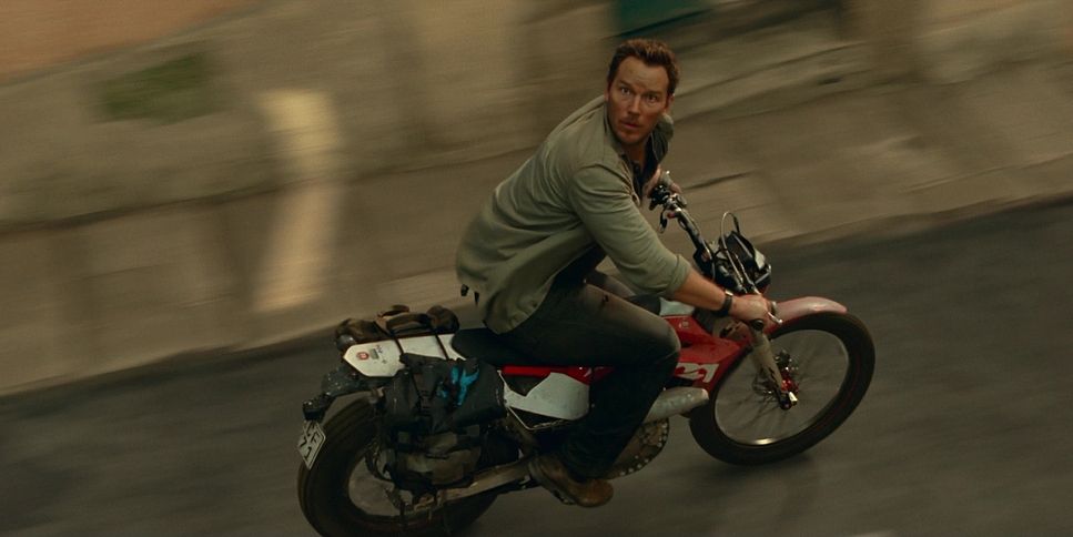 a man riding a motorcycle down a street