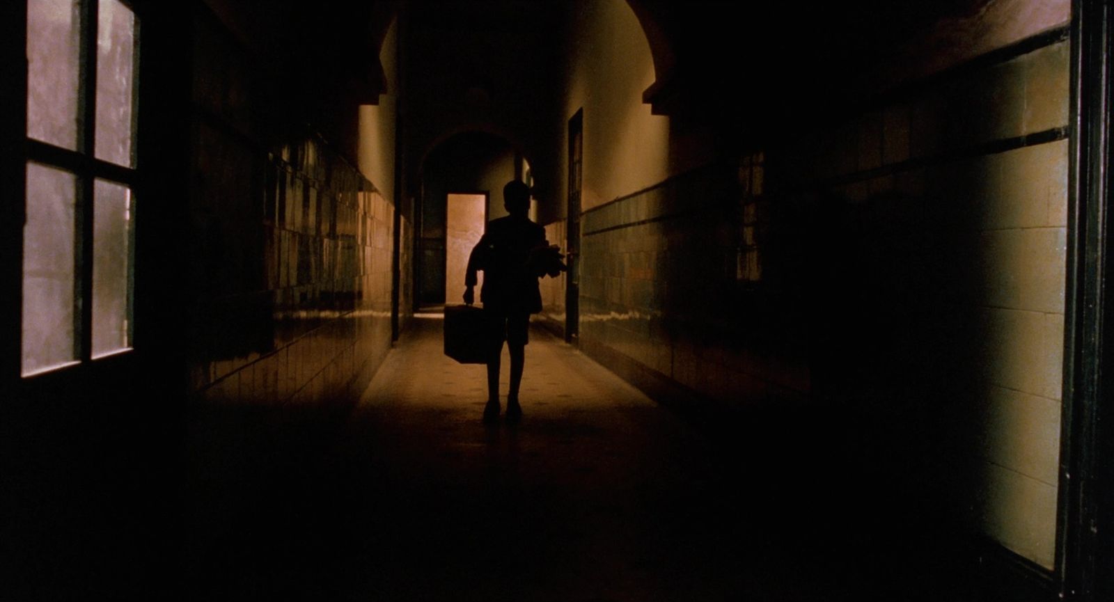 a person is walking down a dark hallway