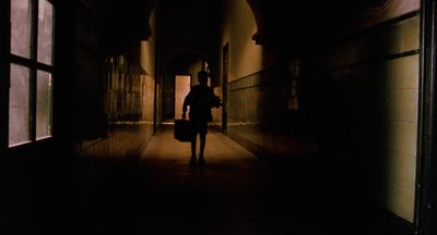 a person is walking down a dark hallway