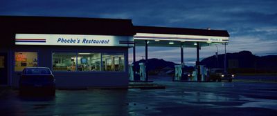 a car is parked in front of a gas station