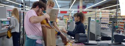 a couple of people standing at a cash register