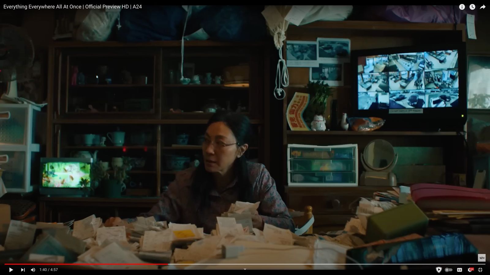 a woman sitting at a table in front of a tv