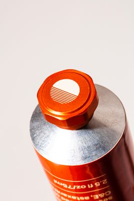 a close up of a red can on a white surface