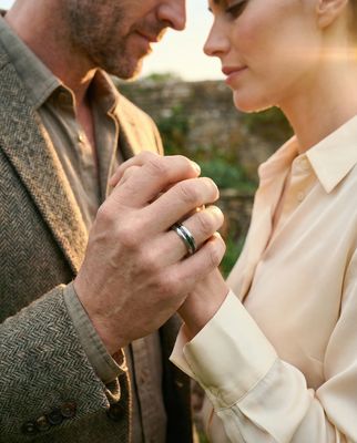 a man and a woman holding hands and looking at each other