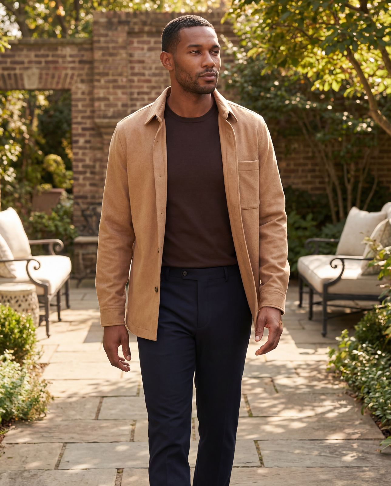 a man walking down a sidewalk in a brown jacket