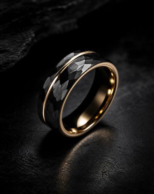 a black and gold wedding ring with a black diamond in the center