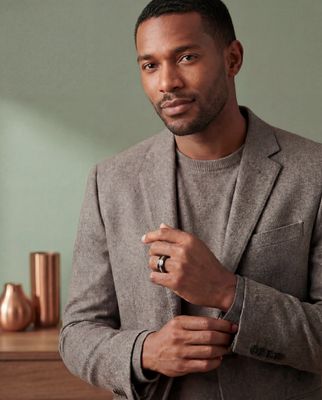 a man in a gray suit and a ring