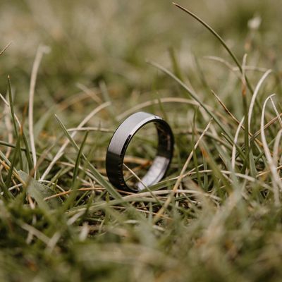 a wedding ring sitting on top of a lush green field