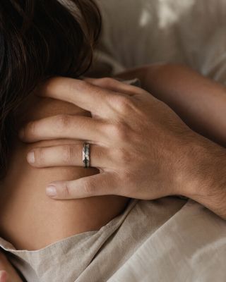 a man holding a woman's hand with a wedding ring