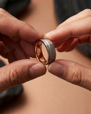 a person holding a wedding ring in their hands
