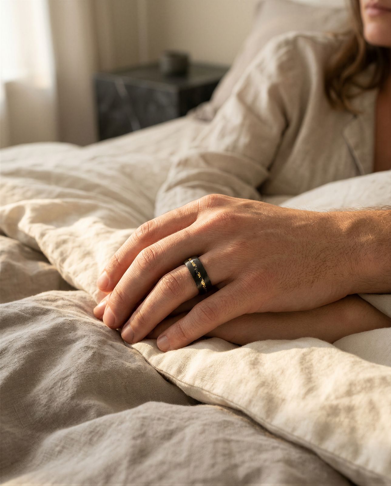 a woman laying in bed with a ring on her finger