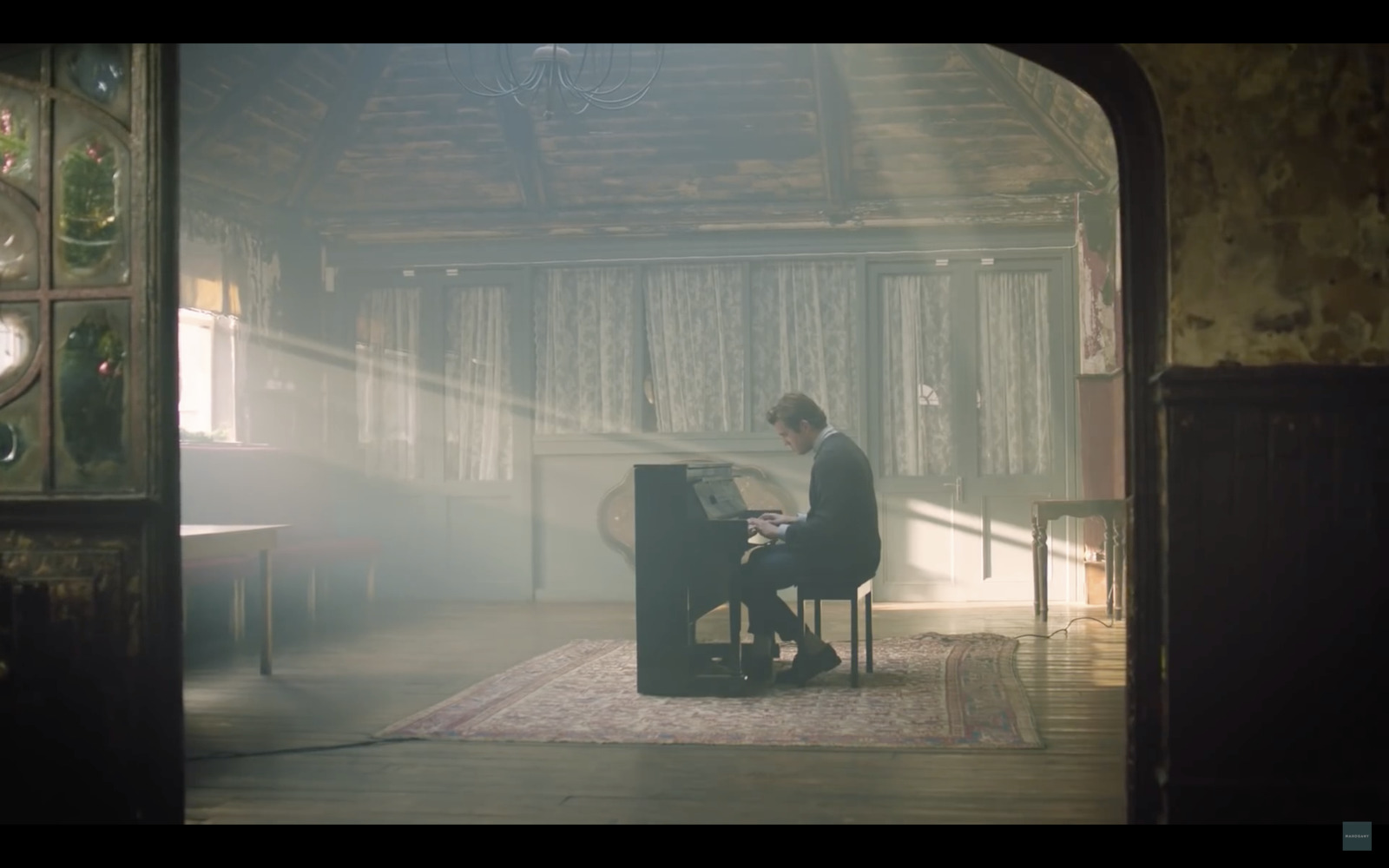 a man sitting at a piano in a room