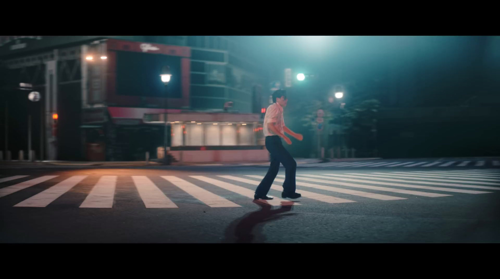 a man standing in the middle of a street at night