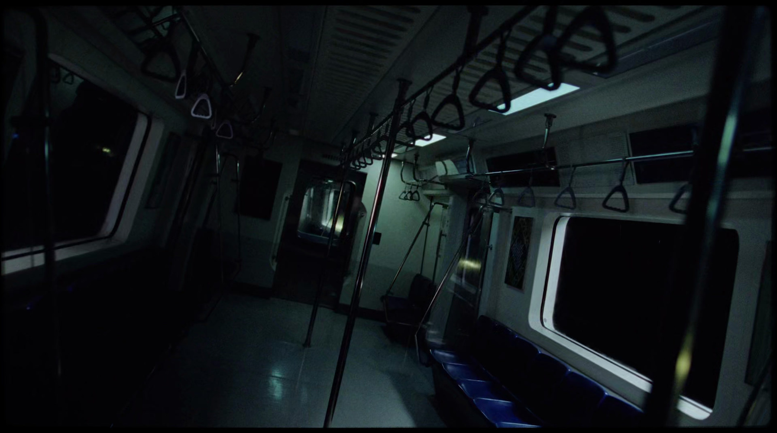 a dimly lit subway car in a dark room