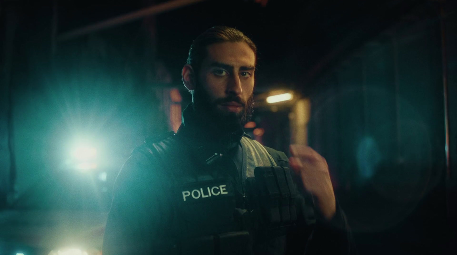 a man in a police uniform standing in a dark room