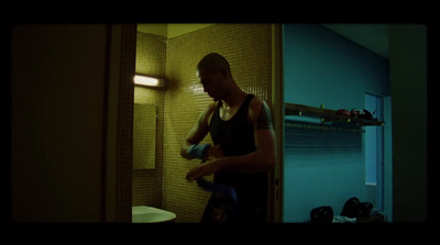 a man standing in a bathroom holding a bottle