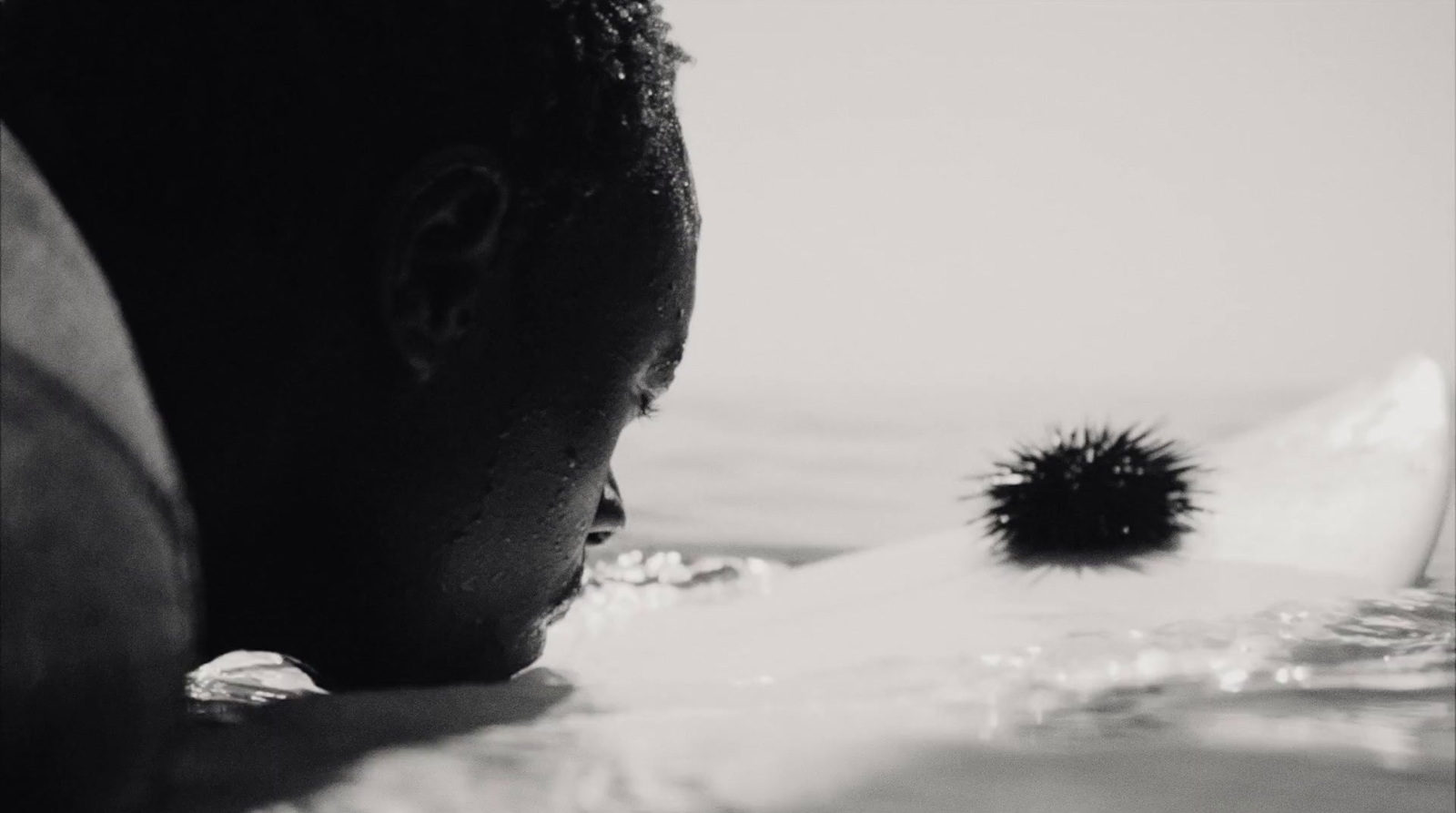 a black and white photo of a man in the water