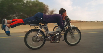 a man laying on the back of a bike