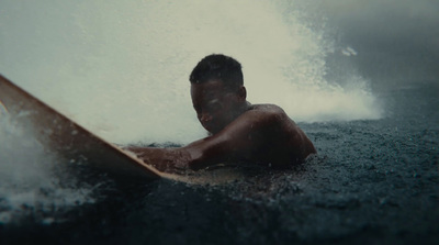 a man riding a wave on top of a surfboard