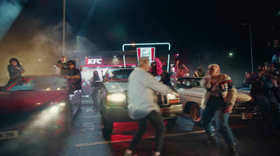 a group of people standing in front of a car at night