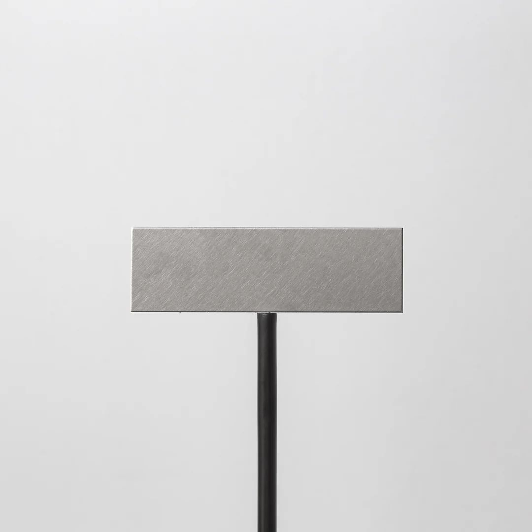 a square metal object on a black stand