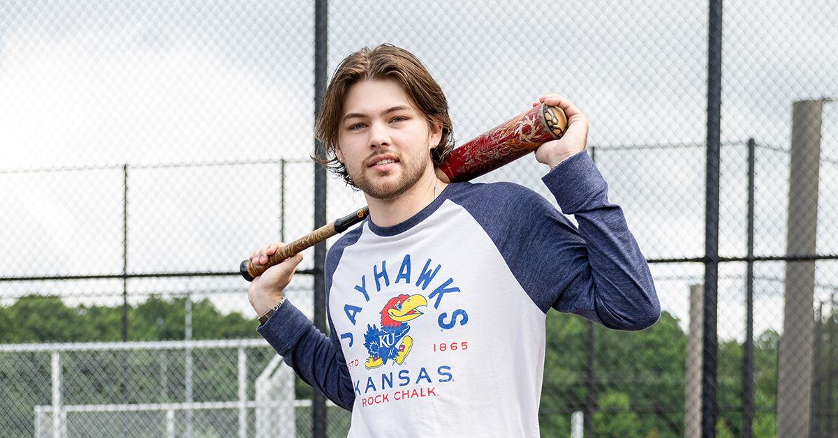 a man holding a baseball bat in his right hand