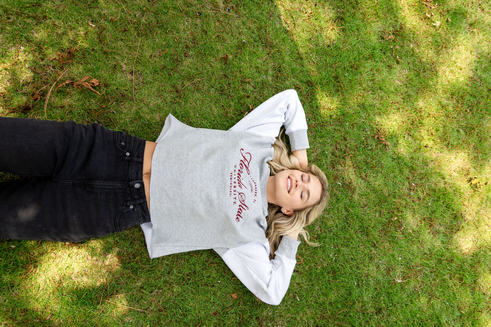 a woman laying on top of a lush green field
