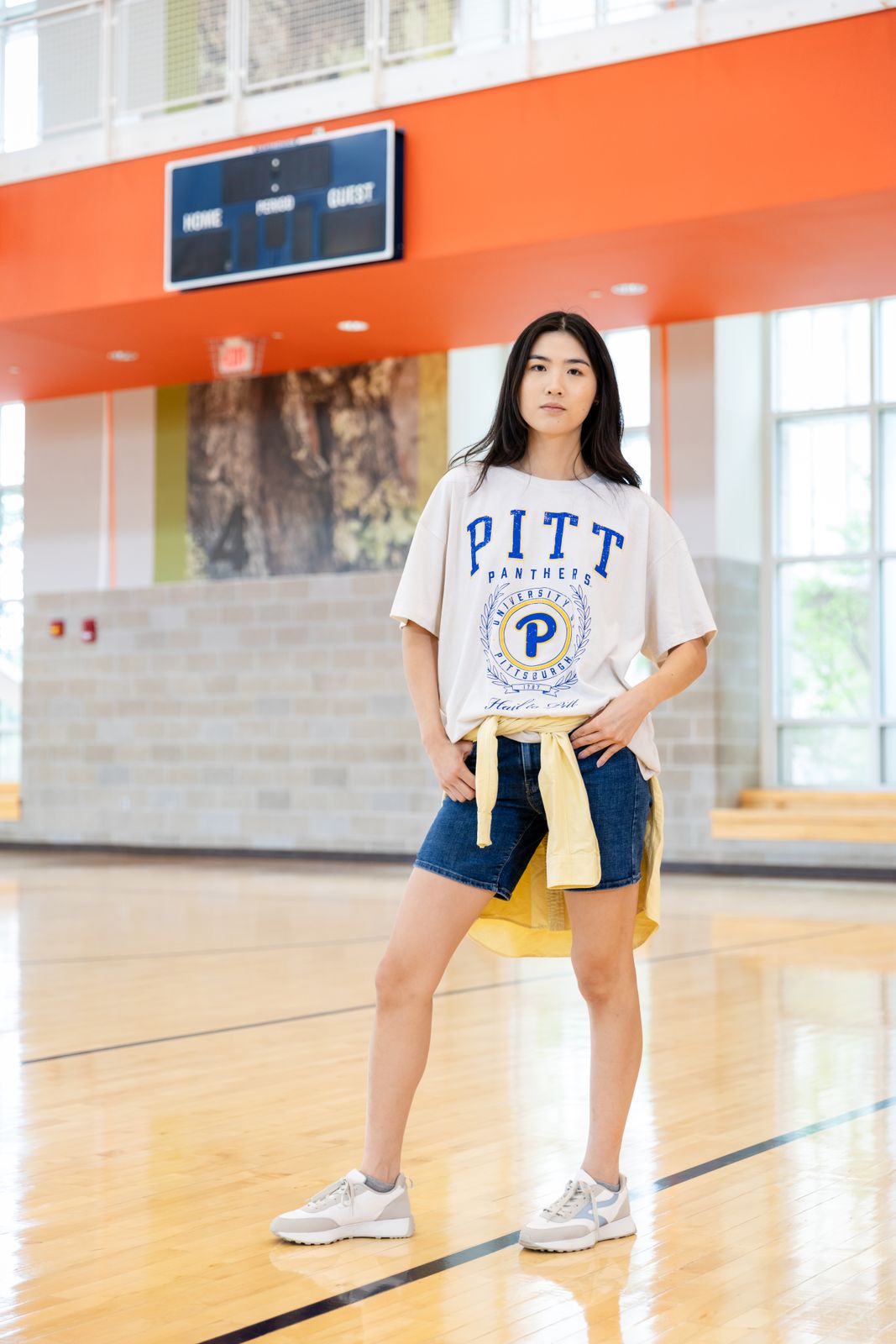 a woman standing on a basketball court in a t - shirt