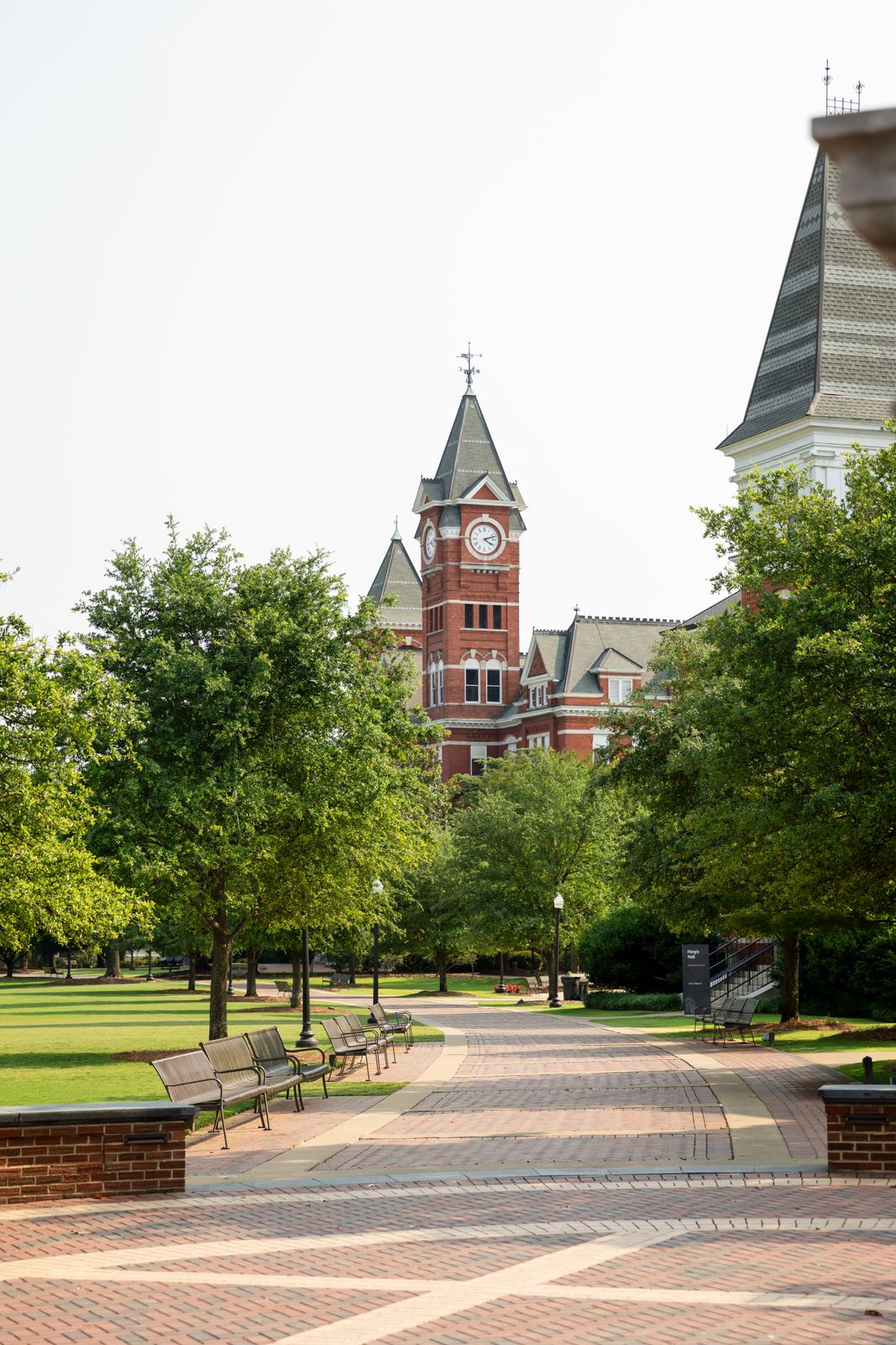 a clock tower in the background of a brick walkway
